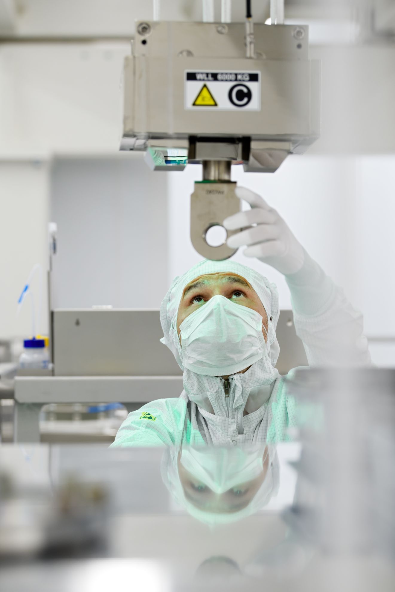 An ASML employee looks up into a machine in the cleanroom An ASML employee looks up into a machine in the cleanroom
