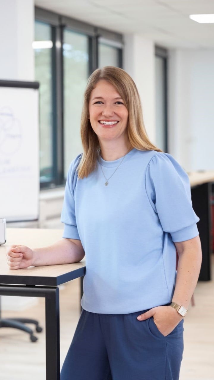 Eine Frau steht an einem Tisch mit einem Moderationskoffer und einem Flipchart im Hintergrund Eine Frau steht an einem Tisch mit einem Moderationskoffer und einem Flipchart im Hintergrund