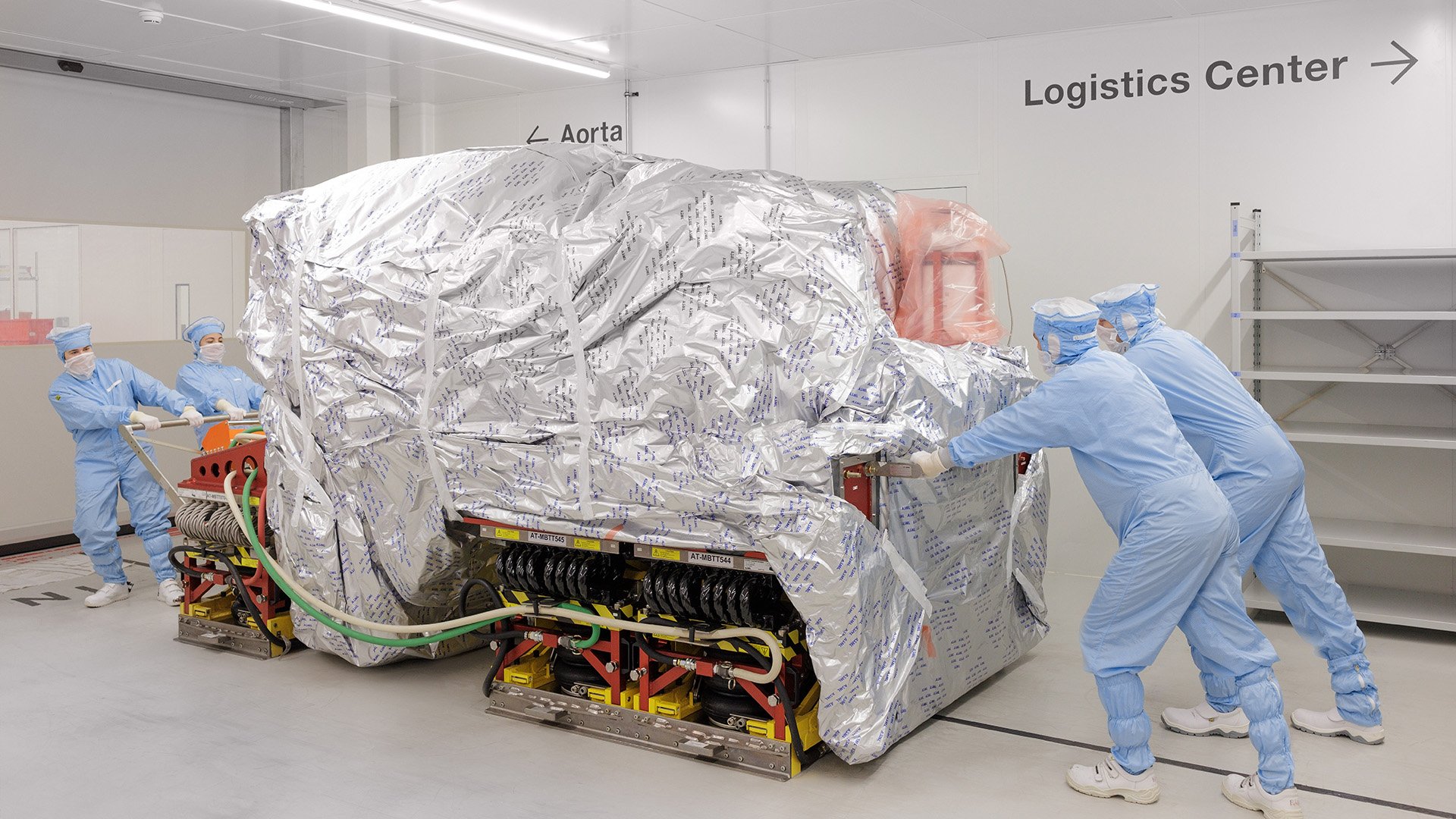 Technicians moving equipment in a cleanroom Technicians moving equipment in a cleanroom