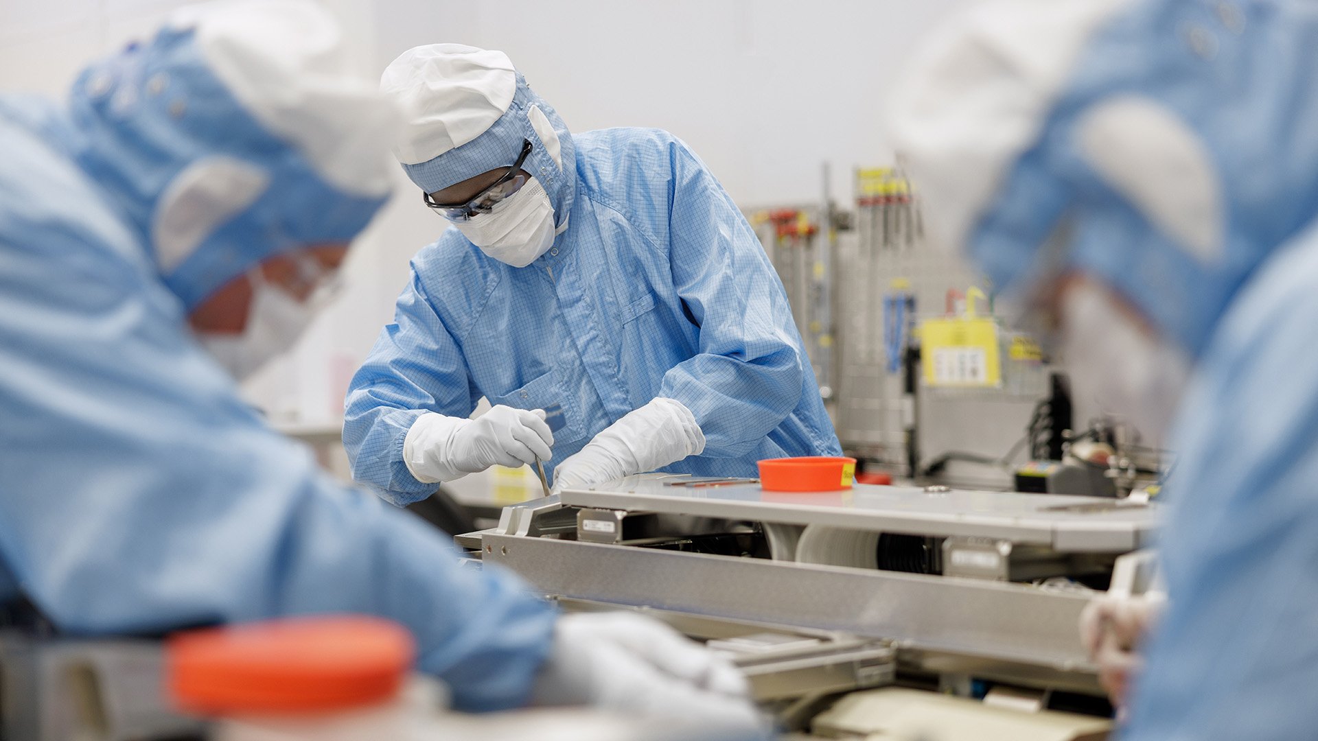 Technicians assembling equipment in a cleanroom Technicians assembling equipment in a cleanroom